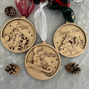 Pallina natalizia a forma di volpe in legno realizzata su misura con slitta di bastoncini di zucchero e albero di Natale