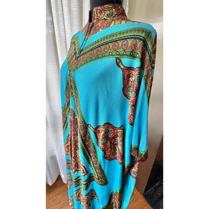 Puede incluir: Una t&uacute;nica de color turquesa brillante con cuello alto y un vibrante estampado de cachemira multicolor en tonos rojo, dorado y verde. La prenda tiene una silueta holgada y fluida con mangas anchas y un dise&ntilde;o de borde detallado en el cuello.