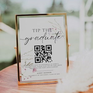 May include: A white sign with a gold frame and floral accents reads "Tip the graduate". A QR code is displayed below the text. The sign also includes the text "If you wish to contribute to Avery's college fund, please scan the QR code above. Thank you for your love & support. Avery Jackson, University of San Diego, Class of 2023."