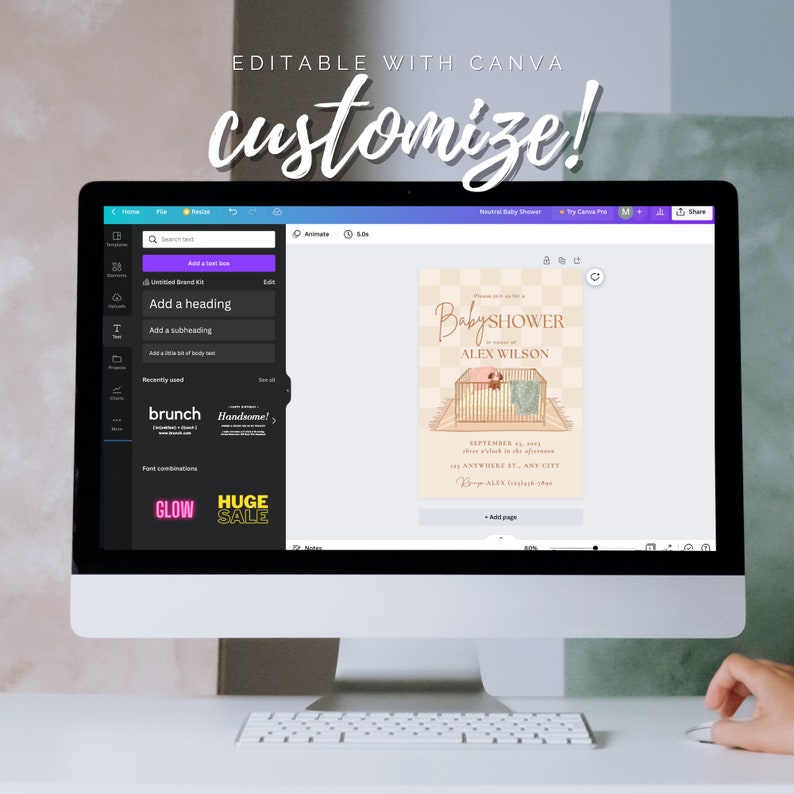 May include: A computer screen displaying a Canva design template for a baby shower invitation. The template features a cartoon illustration of a baby in a crib with a dog. The text on the invitation reads "Baby Shower in honor of Alex Wilson".