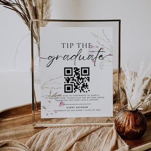 May include: A white sign with a gold frame and floral accents reads "Tip the graduate". A QR code is displayed with the text "If you wish to contribute to Avery's college fund, please scan the QR code above. Thank you for your love & support. Avery Jackson, University of San Diego, Class of 2023."