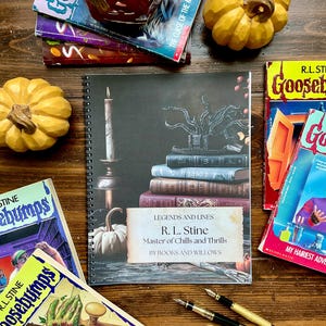Peut inclure: Plusieurs livres de R.L. Stine, dont des Goosebumps, et un carnet à spirales intitulé "Legends and Lines" avec une pile de livres et une bougie. La couverture du carnet affiche le texte "R. L. Stine, Master of Chills and Thrills, By Books and Willows."