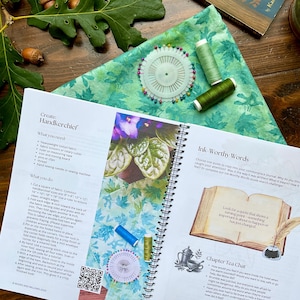 Puede incluir: Un libro abierto con encuadernaci&oacute;n en espiral, con texto e ilustraciones sobre la creaci&oacute;n de un pa&ntilde;uelo. Tambi&eacute;n se ven una tela verde estampada, carretes de hilo y alfileres de costura, lo que sugiere un tema artesanal.
