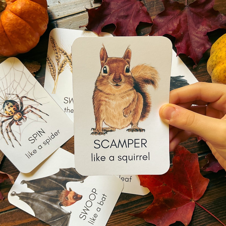 May include: A card featuring a detailed illustration of a brown squirrel with the word "SCAMPER" and the phrase "like a squirrel" below. Other cards with illustrations of a spider, bat, and wheat are visible.