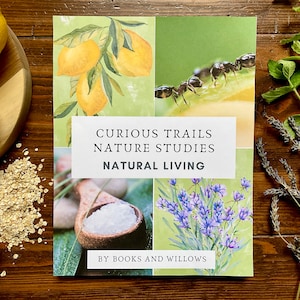 Op de afbeelding: Een boekomslag met de titel "Curious Trails Nature Studies Natural Living" wordt omringd door afbeeldingen van citroenen, mieren, lavendel en een houten lepel. Het boek ligt op een houten oppervlak met haver en een kom suiker.