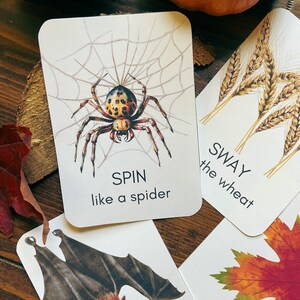 May include: A collection of illustrated cards with autumn-themed images. One card features a spider in a web with the text "SPIN like a spider." Other cards show wheat, a bat, and a maple leaf, each with related action words.