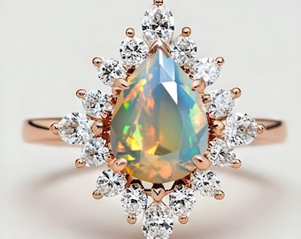 May include: A pear-shaped opal ring with a rose gold band and a halo of smaller diamonds.