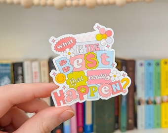 May include: A pink and blue sticker with the text "What is the best that could happen?" in a retro font. The sticker has a smiley face, flowers, and stars.
