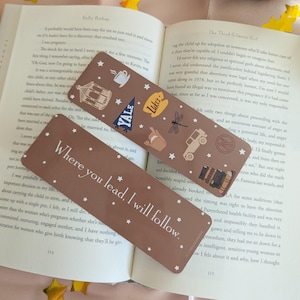 May include: Two brown bookmarks with white stars and themed illustrations. One bookmark reads "Where you lead, I will follow." The other has a coffee cup, Yale pennant, and other icons.