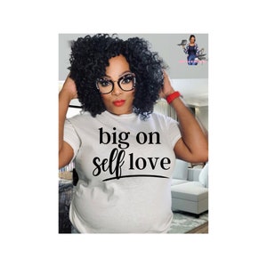 May include: White t-shirt with black text that reads "big on self love".
