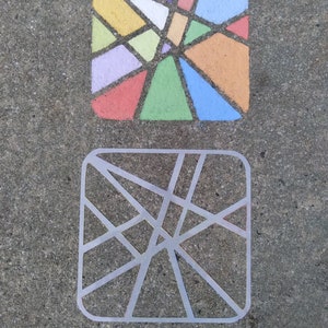 Puede incluir: Un diseño geométrico colorido dibujado con tiza sobre una superficie de hormigón gris. El diseño está formado por una variedad de colores, incluyendo rojo, naranja, amarillo, verde, azul y morado. El diseño está rodeado por un contorno blanco.