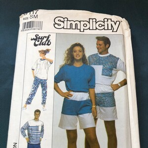 May include: Simplicity sewing pattern for a blue and white striped shirt, blue trousers, a blue and white striped shirt, blue shorts, a white shirt with a blue and white patterned design, and blue and white patterned shorts. The pattern is for size SM and is part of the Surf Club collection.