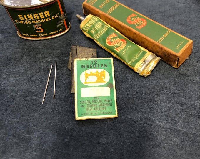 Vintage sewing machine items, oil can, lubricant and round shank needles