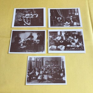 May include: Five vintage black and white photographs of a classroom of children learning to sew. The photos show children of various ages sitting at tables and sewing with needles and thread. The photos are printed on postcards with a white border.