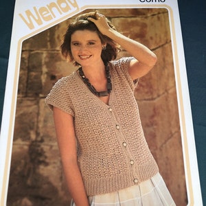 Peut inclure: Un modèle de tricot pour un cardigan en tricot beige avec un col en V et une fermeture à boutons. Le modèle s'appelle "Como" et est de Wendy, numéro de modèle 2505. Le modèle est pour les tailles 76-107 cm.