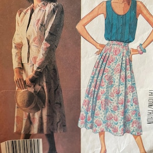 May include: A vintage sewing pattern featuring two women's outfits. The first outfit is a white and pink floral print skirt and jacket. The second outfit is a teal sleeveless top and a pink and white floral print skirt. The pattern is labelled "Laura Ashley" and has a barcode.