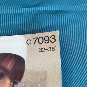 Pode incluir: Close-up de uma etiqueta de papel castanho com o texto "C 7093 32-38" impresso em preto.