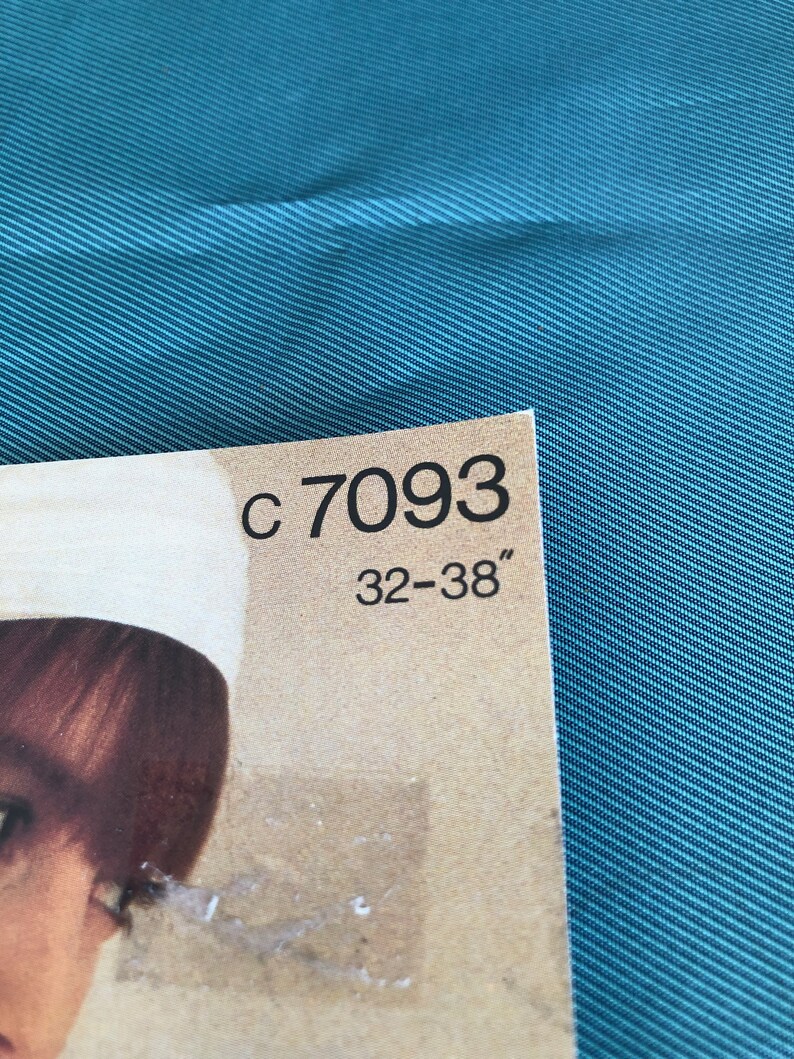 Pode incluir: Close-up de uma etiqueta de papel castanho com o texto "C 7093 32-38" impresso em preto.