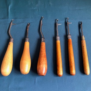 May include: Six wooden crochet hooks with metal tips. The hooks are different sizes and have a natural wood finish.