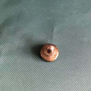 May include: A silver metal bottle stopper with a round top.