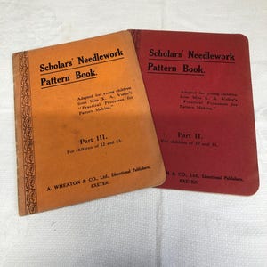 May include: Two vintage "Scholars' Needlework Pattern Book" guides. One is orange, labeled Part III for ages 12 and 13. The other is red, labeled Part II for ages 10 and 11. Both books have the same title and author information.