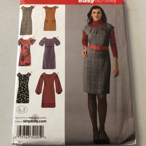 May include: Simplicity sewing pattern number 2846, easy-to-sew, for sizes 4, 6, 8, 10, and 12. The pattern includes five different dress designs, including a plaid dress with a red belt, a floral dress, a polka dot dress, and two solid colour dresses. The pattern is for women's clothing.