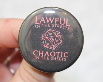 May include: A black button with a silver border features a pink 20-sided die and the text "Lawful in the Streets, Chaotic in the Sheets".