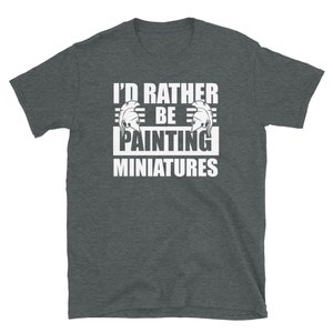 May include: A dark heather grey t-shirt with the text "I'd rather be painting miniatures" in white. The text is framed by two white Roman helmet illustrations.