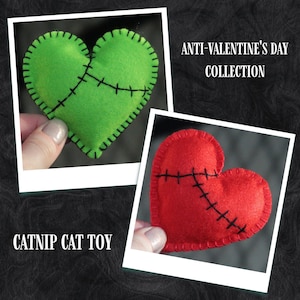 Può includere: Due giocattoli per gatti in feltro a forma di cuore con cuciture nere. I cuori sono verdi e rossi. Il testo "ANTI-VALENTINE'S DAY COLLECTION" è nella parte superiore dell'immagine. Il testo "CATNIP CAT TOY" è nella parte inferiore dell'immagine.