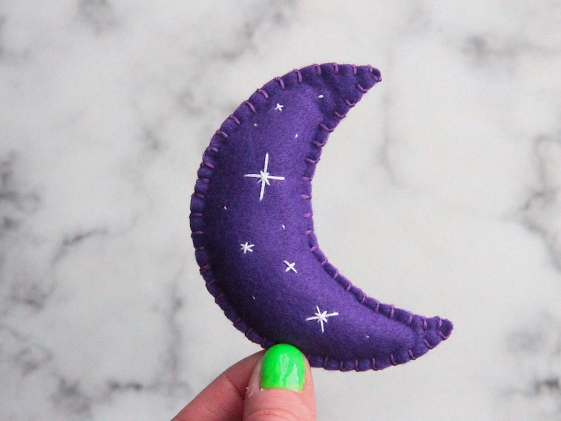 May include: Purple felt crescent moon with white embroidered stars.