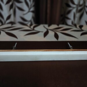 May include: White marble drawer pull with a wood top and silver metal accents.