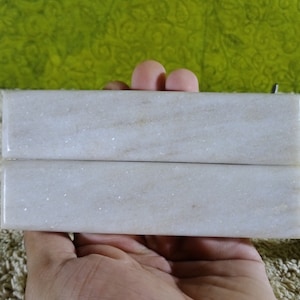 May include: Two white marble slabs with a subtle sparkle, perfect for crafting or decorative projects.