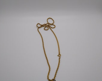 May include: A gold-toned necklace with a large, amber-colored pendant. The pendant has a teardrop shape, encased in a gold-colored metal frame. The chain is a delicate rope style, with a clasp closure.