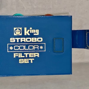 May include: Blue leather case with a gold crown logo and the text "King Strobo *Color* Filter Set".