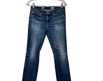May include: A pair of blue denim jeans featuring a classic five-pocket design, a button and zipper fly closure, and a faded wash effect on the thighs. The jeans have a straight-leg cut with visible stitching details and metal rivets.