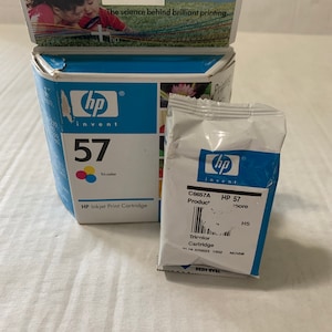 May include: A close-up of an HP 57 tri-color inkjet print cartridge. The packaging is blue and white with the HP logo and the text "invent". The cartridge is labeled with the product number C6657A and the text "HP 57".
