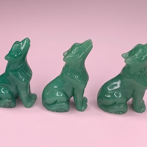 Könnte beinhalten: Vier grüne Jade-Wolf-Figuren, jede mit einer detaillierten Schnitzerei eines Wolfes, der zum Mond heult. Die Figuren sitzen alle in einer sitzenden Position mit dem Kopf nach hinten geneigt.
