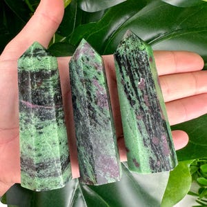 May include: Three green, black and pink zoisite crystal points. The points are smooth and polished, and they have a natural, organic look.