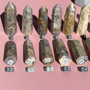 May include: Fifteen hexagonal-shaped crystal points with a variety of brown, white, and purple patterns. The points are numbered 1 through 15.