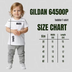 May include: A toddler wearing a white t-shirt and gray pants. The image includes a size chart for Gildan 64500P toddler t-shirts, showing sizes 2T to 6T with width and length measurements in inches.