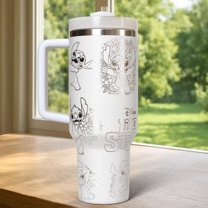 May include: White travel mug featuring illustrations of Stitch from Lilo & Stitch. The mug has a white handle, lid, and a silver rim. The text "Aloha Fun!" and "Disney Lilo & Stitch" are visible on the mug.