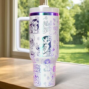 May include: White travel mug with illustrations of Lilo & Stitch characters. The mug has a white handle and lid, with the words "Aloha Stitch" and "Summer" in a colorful design. The mug is approximately 23 cm tall.