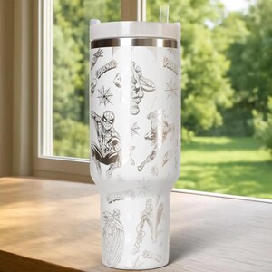 Puede incluir: Vaso t&eacute;rmico blanco con ilustraciones y logotipos de Spider-Man. El vaso tiene una tapa blanca y una banda plateada. Una pajita transparente est&aacute; insertada en la tapa. El dise&ntilde;o incluye im&aacute;genes de Spider-Man en varias poses.
