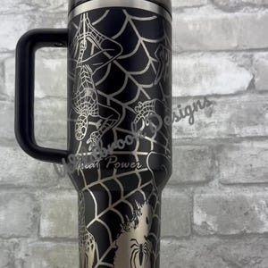 Puede incluir: Vaso negro con asa, con un dise&ntilde;o de telara&ntilde;a plateada e ilustraciones de Spider-Man. El vaso incluye el texto "With Great Power". Tiene tapa y pajita negras.