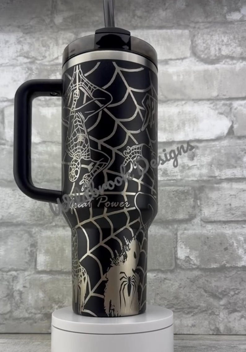 Puede incluir: Vaso negro con asa, con un dise&ntilde;o de telara&ntilde;a plateada e ilustraciones de Spider-Man. El vaso incluye el texto "With Great Power". Tiene tapa y pajita negras.