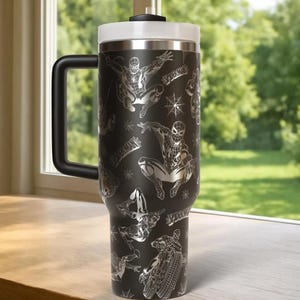 Puede incluir: Taza de viaje negra con un dise&ntilde;o de Spider-Man. La taza tiene un asa negra, una tapa blanca y un borde plateado. Los gr&aacute;ficos de Spider-Man son plateados e incluyen el logotipo de Spider-Man y dise&ntilde;os de telara&ntilde;as.