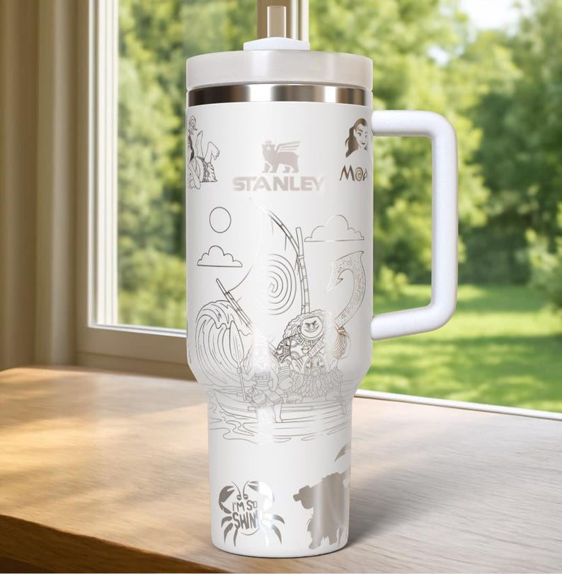 May include: White Stanley tumbler with a handle, lid, and straw. The tumbler features etched illustrations of characters and scenes from a popular animated movie. The Stanley logo is visible. The text "I'M SO SHINY" is also etched on the tumbler.