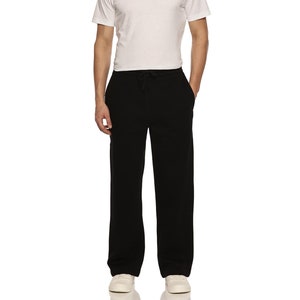 Peut inclure: Un pantalon de survêtement noir avec une taille à cordon. Le pantalon de survêtement est ample et a une jambe droite.