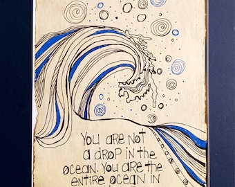 May include: Hand-drawn artwork featuring a stylized wave with blue and black lines, and the quote "You are not a drop in the ocean. You are the entire ocean in a drop - Rumi." The artwork is framed in a white mat and a dark blue frame.