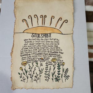Pu&ograve; includere: Un'illustrazione disegnata a mano di un sole con le parole "SOULSHINE" scritte in inchiostro nero. Il testo sotto il sole dice: "Quando non riesci a trovare la luce che ti ha portato attraverso una giornata nuvolosa, quando le stelle non brillano, ti senti come se ti fossi perso. Quando quelle luci di candela a casa bruciano cos&igrave; lontano, beh, devi lasciare che la tua anima brilli come faceva mio padre. Parlando di anima, &egrave; meglio del sole, &egrave; meglio della luna. Certo che &egrave; meglio della pioggia. Signore, ora la gente non se ne preoccupa, dobbiamo tutti ottenere questa anima che brilla fino all'alba."